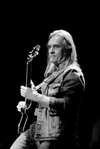 Юрий Рыманов, тот самый парень, который когда-то зажигал на гитаре в группе 'Любэ', больше не с нами. 🎸 Его имя не всегда было на первых полосах, но его музыка звучала в каждом доме. 'Конь', 'Давай за...', 'Там, за туманами' — эти песни стали частью нашей культуры. Рыманов был тем, кто делал их такими живыми. О причинах смерти пока ничего не известно, но это не главное. Главное — память. Его гитара говорила за него, и она продолжит говорить даже сейчас. 🕯️ Группа 'Любэ' уже потеряла несколько своих легенд, и это печально. Но их музыка остается с нами. Как и память о Юрии. Спасибо за всё, Юрий. Ты был настоящим.. Юрий Рыманов, Любэ, гитарист, музыка, культура