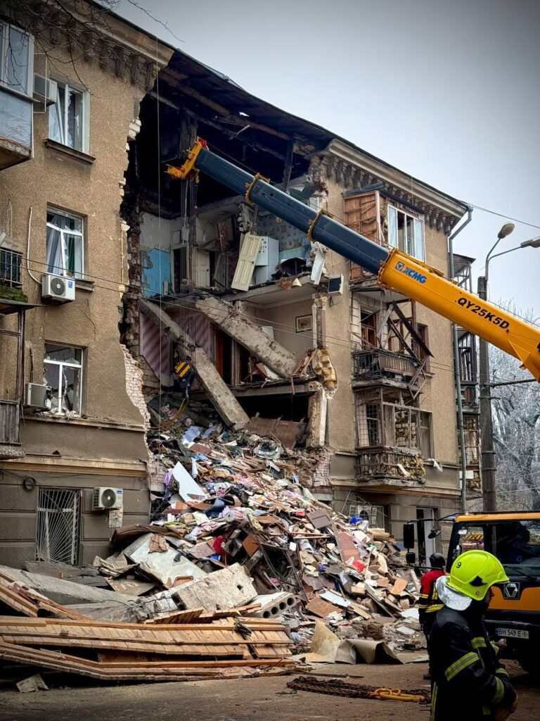 Одесса подверглась масштабной атаке беспилотников в ночь на текущие сутки. По данным городской военной администрации, в результате ударов повреждены более 40 зданий. Количество пострадавших достигло 23 человек, еще трое числятся пропавшими без вести. Руководитель городской военной администрации Сергей Лысак подтвердил, что поисково-спасательные работы продолжаются. На месте происшествия работают экстренные службы, которые оценивают масштабы разрушений и оказывают помощь пострадавшим. Фотографии с места событий демонстрируют значительные повреждения инфраструктуры. Власти города призывают жителей соблюдать осторожность и следовать указаниям спасателей. Ситуация остается напряженной, детали атаки уточняются.. Одесса, Беспилотники, Сергей Лысак, Военное дело, ЧП