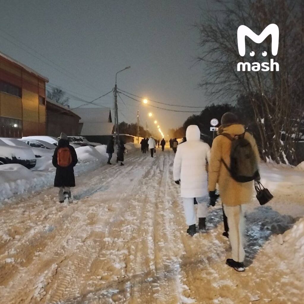 Рекордный снегопад в Подмосковье стал причиной масштабных транспортных проблем. На дорогах образовались многокилометровые заторы, что вынудило многих жителей бросить автомобили и добираться до домов пешком. На федеральных трассах, включая Домодедовское шоссе, движение практически остановилось. Десятки фур и легковых автомобилей застряли в снежных заносах. Водители и прохожие совместными усилиями пытаются вытянуть машины из снега. Пассажиры общественного транспорта также столкнулись с трудностями. Автобусы двигаются крайне медленно, а некоторые пассажиры предпочитают выходить прямо на дороге и идти пешком. Время в пути для многих жителей увеличилось до 4-5 часов. Ситуация осложняется продолжающимся снегопадом, который, по прогнозам метеорологов, продлится еще несколько часов. Спецслужбы и дорожные службы работают в усиленном режиме, чтобы восстановить движение на основных магистралях.. Подмосковье, снегопад, транспорт, заторы, Домодедовское шоссе