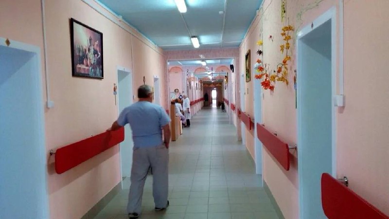 Прокопьевский психоневрологический интернат стал эпицентром скандала. Большинство умерших скончались от сердечных проблем, а причиной массовых госпитализаций стала протухшая еда. 🍖💀 Пациенты жаловались на высокую температуру, головную боль и кашель, но жаропонижающие им не выдавали. В больницы не везли до тех пор, пока ситуация не стала достоянием Сети. Массовая госпитализация началась только после публикаций. 📰 Условия в интернате были ужасными: мясо, рыбу и овощи измельчали в одной мясорубке из-за отсутствия оборудования. В корпусах было холодно, а в аптечках не хватало базовых препаратов. ❄️💊 Ранее мы сообщали о 9 смертях в этом же интернате, предположительно из-за гриппа типа А. Теперь ситуация вышла на новый уровень. ⚠️. Прокопьевск, психоневрологический интернат, госпитализация, протухшая еда, Кемеровская область