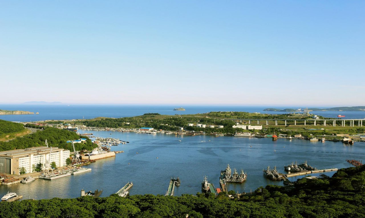 Во Владивостоке разгорается юридический спор вокруг бухты Улисс, которая была передана в собственность Военно-морского флота (ВМФ) по решению суда. Местные предприниматели, ведущие бизнес на этой территории с начала 2000-х годов, оспаривают это решение, утверждая, что суд опирался на документы почти вековой давности. Бухта Улисс, расположенная рядом с мостом на остров Русский, является важной промышленной гаванью, где также базируются корабли Тихоокеанского флота. В прошлом году Генпрокуратура добилась передачи территории в пользование Минобороны, что поставило местный бизнес в сложное положение. Предприниматели лишились земли и инвестиций без компенсации. Согласно иску Генпрокуратуры, бухта изначально предназначалась для нужд обороны, а сделки по её продаже в 1990-х годах были признаны недействительными. Главным доказательством в суде стали справки о передаче территории военным частям в 1930-х годах. Однако ответчики утверждают, что эти документы не имеют юридической силы, так как в них отсутствуют чёткие границы и кадастровые данные. На данный момент четыре компании уже лишились своих активов без компенсации, а ещё 19 находятся в зоне риска. Предприниматели требуют пересмотра дела и учёта официального документа о высвобождении земель из владения Минобороны, который суд отказался приобщить к делу.. Владивосток, бухта Улисс, ВМФ, Генпрокуратура, бизнес